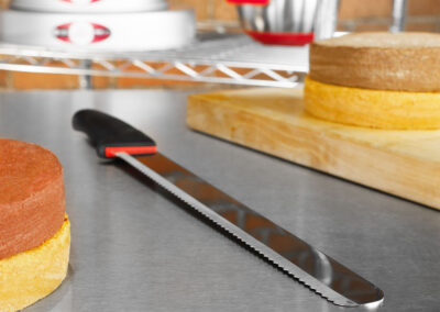 سكين الخبز والكيك مع طبقات الكيك في مخبز من الطوب