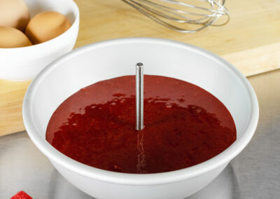 Heating Core Rod within red velvet cake batter in a hemisphere cake pan in a bakery