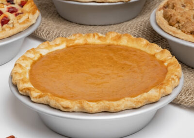 Pumpkin Pies in small pie pans in a bakery