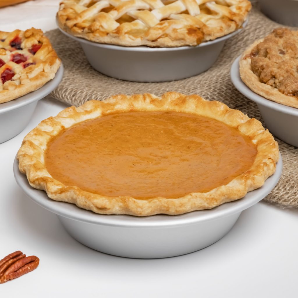 Pumpkin Pies in small pie pans in a bakery