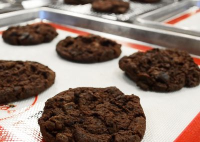 Teglie su teglie da forno in silicone con biscotti al cioccolato in una panetteria