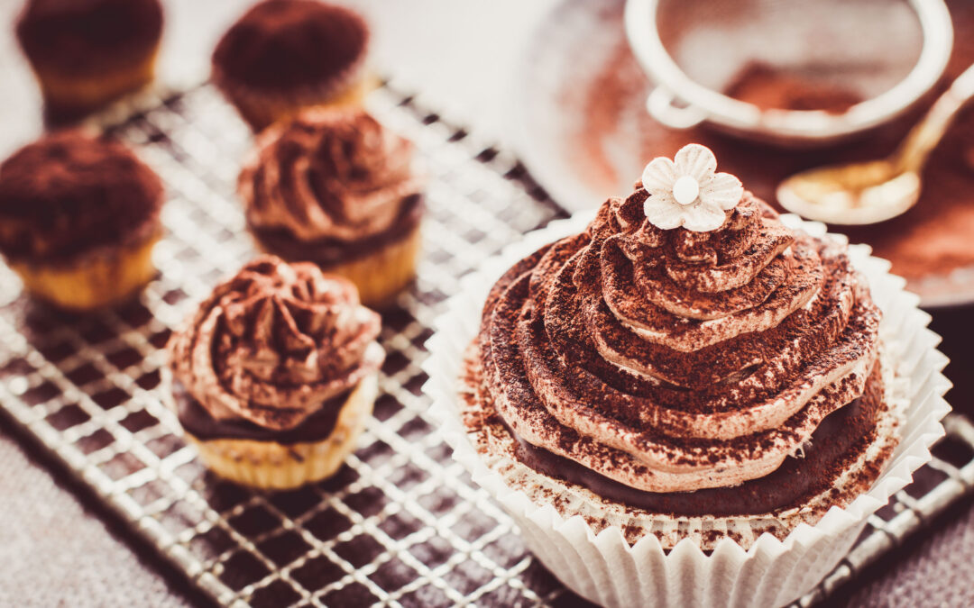 Chocolate cupcakes with frosting and cocoa powder