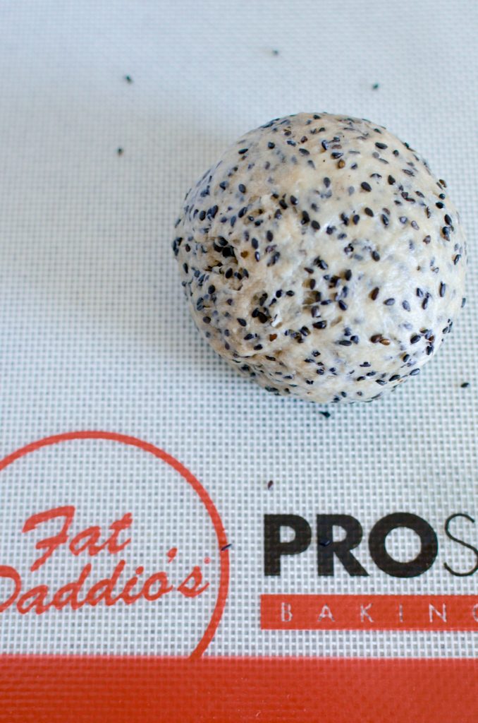 Rolling black sesame crisps before baking