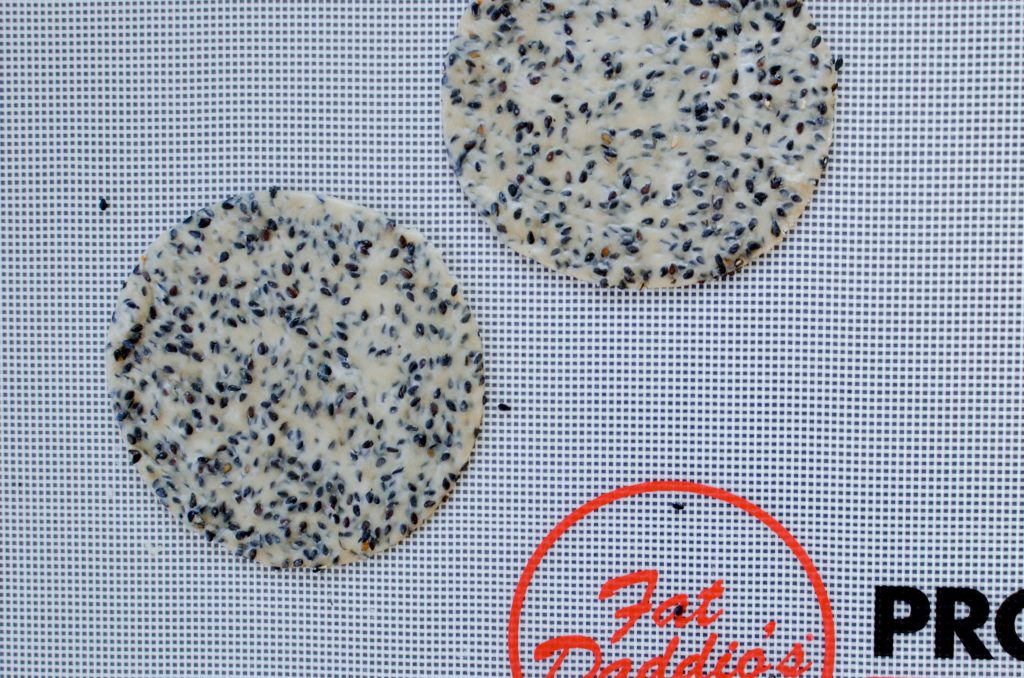 Flattened black sesame crisps before baking