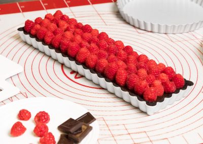 Rectangle raspberry tart on a silicone mat in a bakery