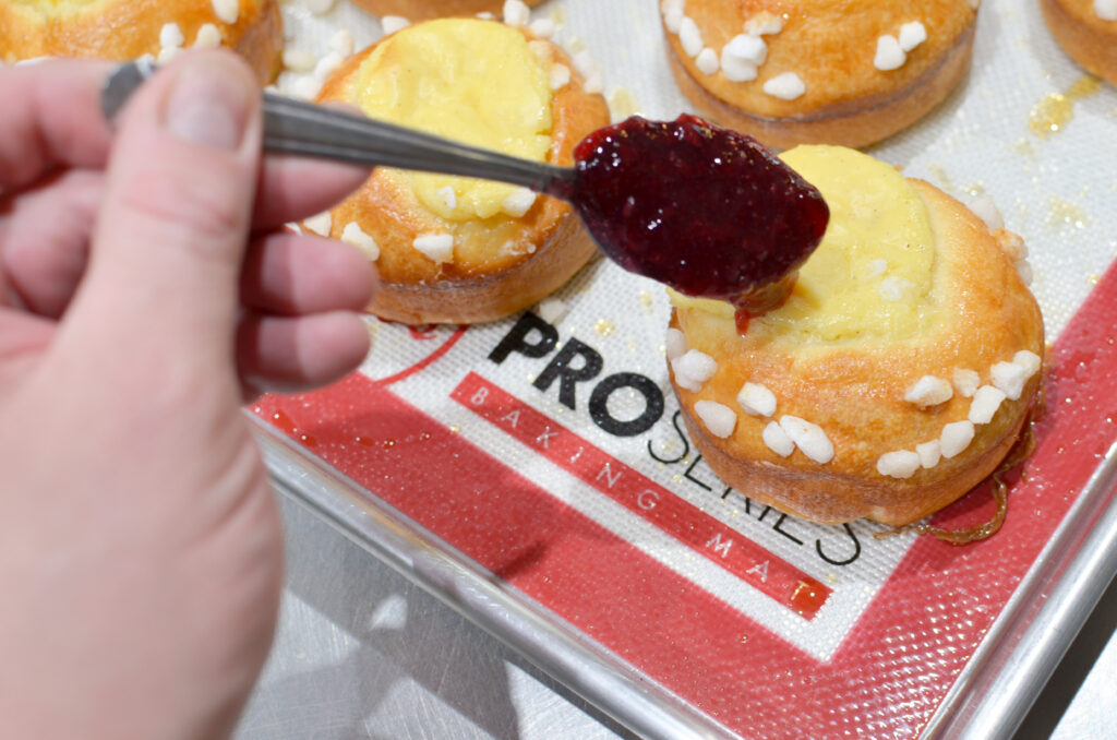 A baker decorating Torta Della Nonna dough on a work mat