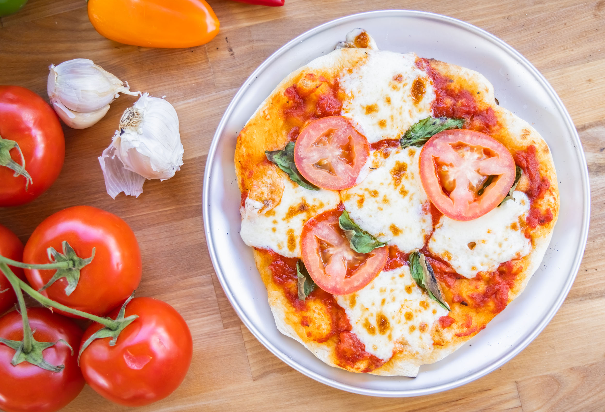 top down view of a margherita pizza on a pizza pan